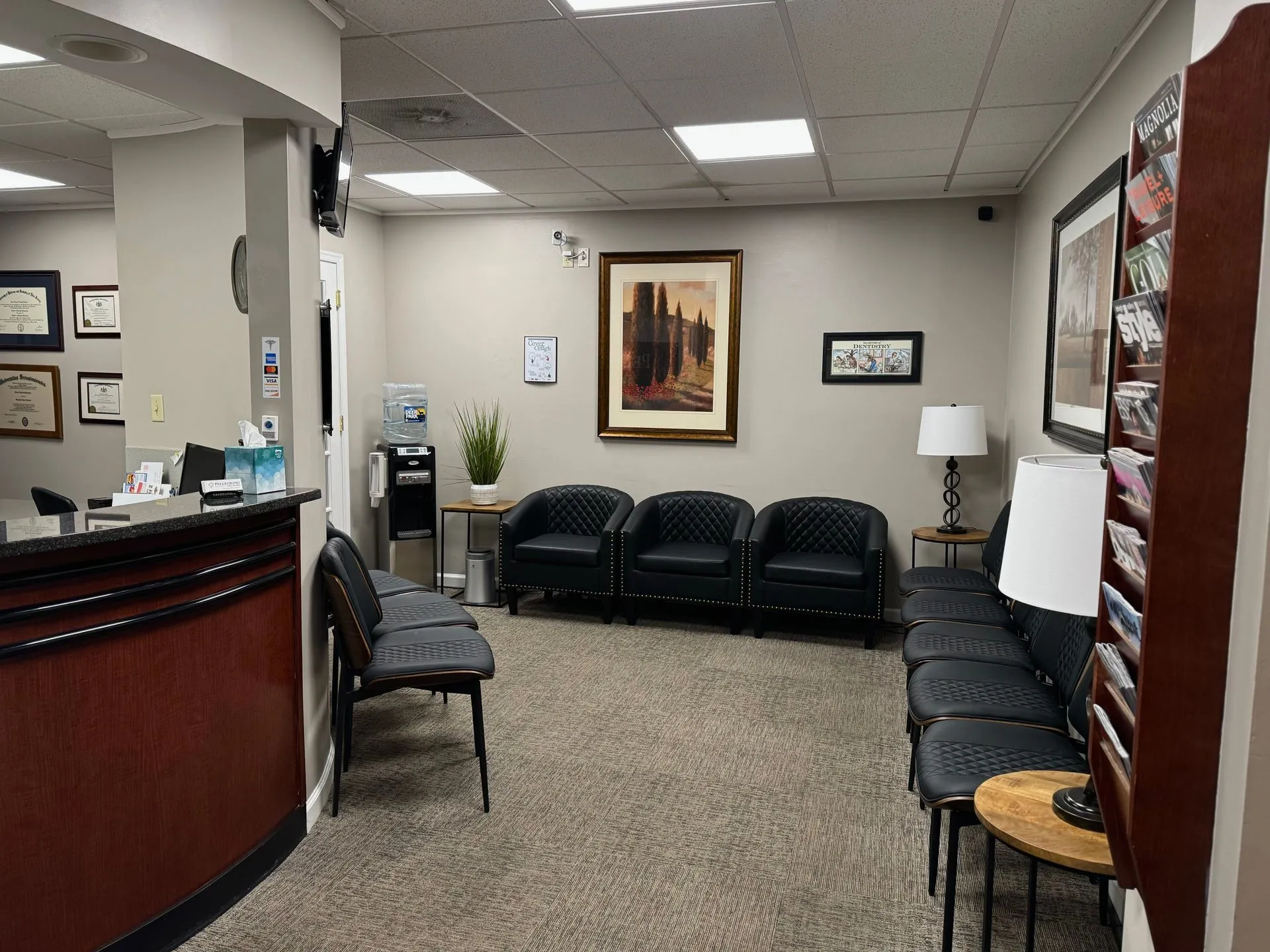 Modern dental office waiting room with seating, reception desk, and professional décor.