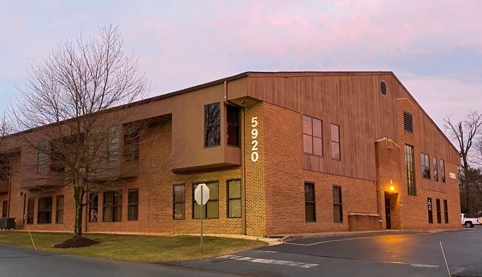 Modern brick dental office building illuminated at dusk with professional exterior lighting and signage.